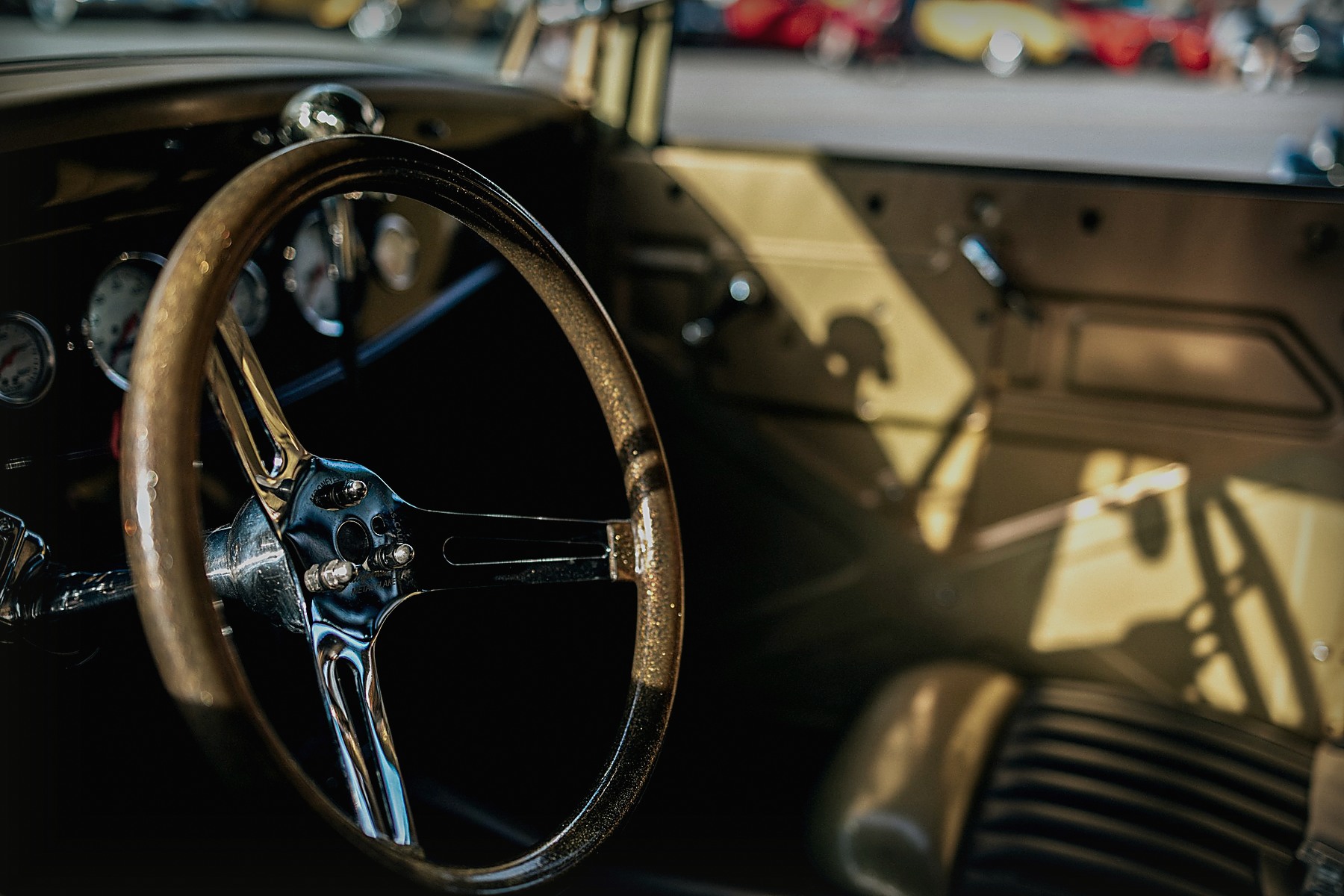 Chrome steering wheel and dashboard inside a vintage car
