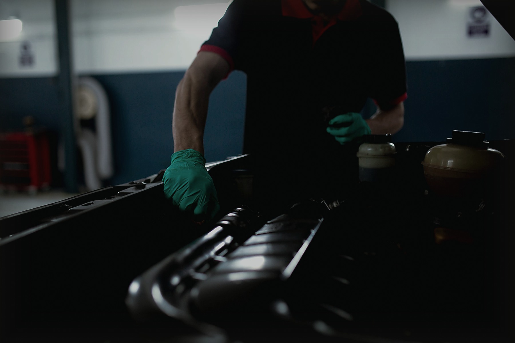 Gloved mechanic working on a car engine